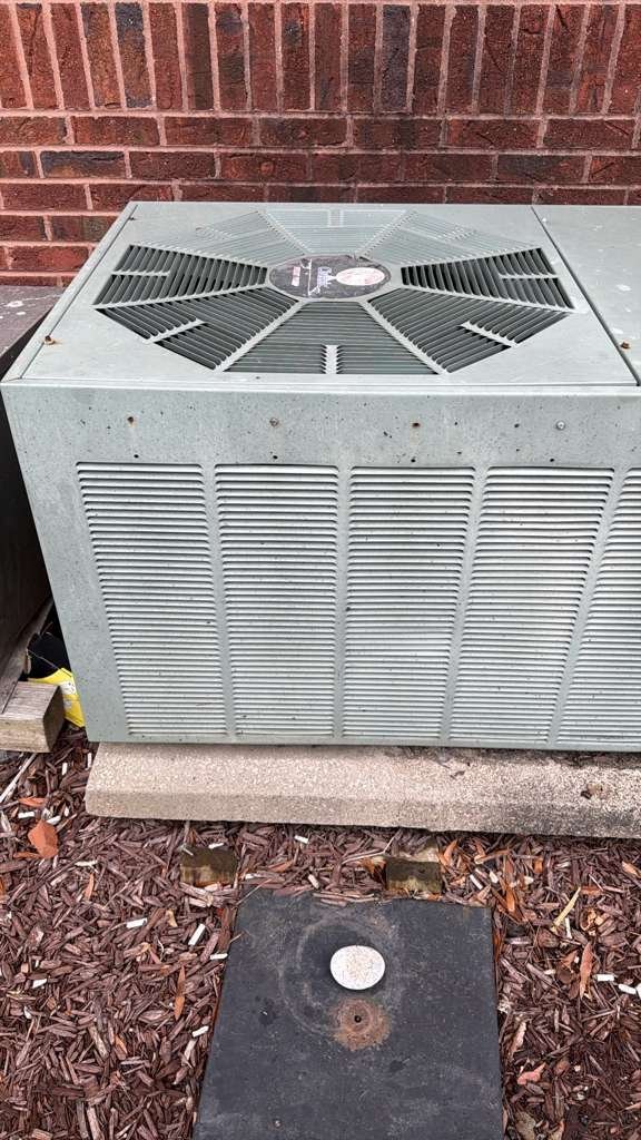 Outdoor condenser beside a brick building